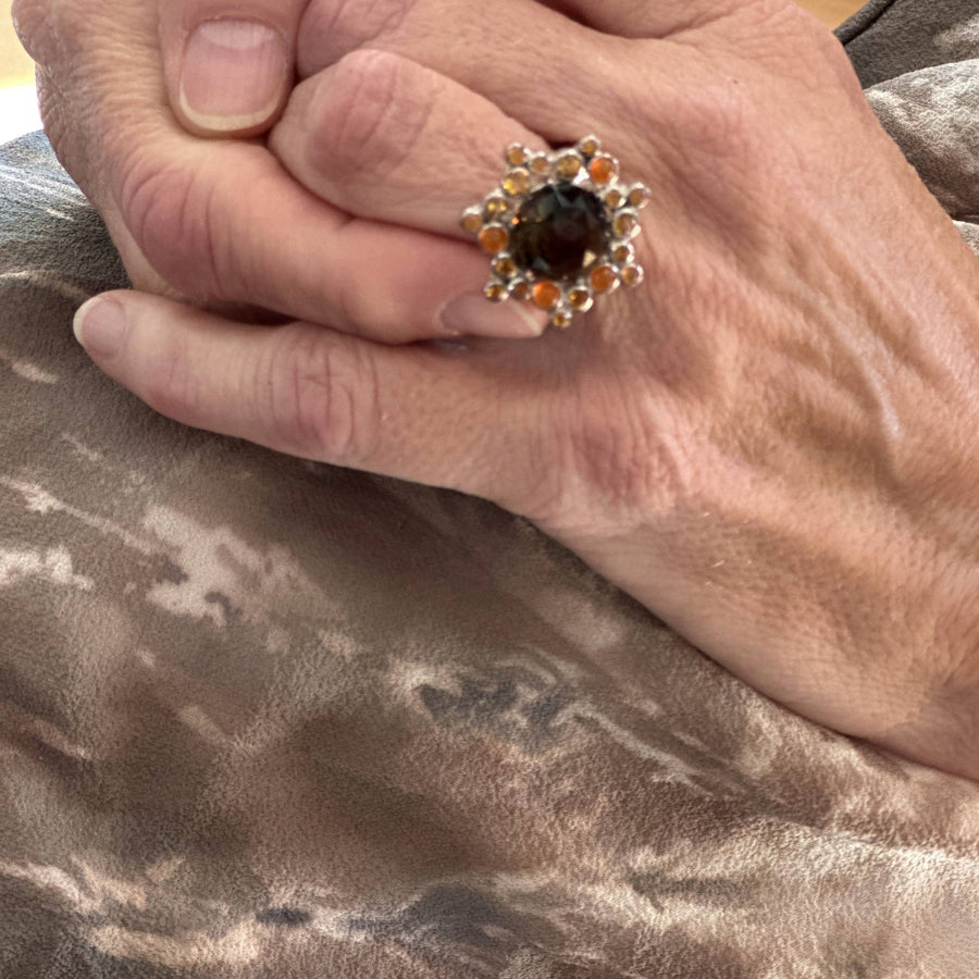 Sterling silver cluster ring featuring a large faceted smoky quartz gemstone surrounded by smaller round citrine and orange carnelian stones
