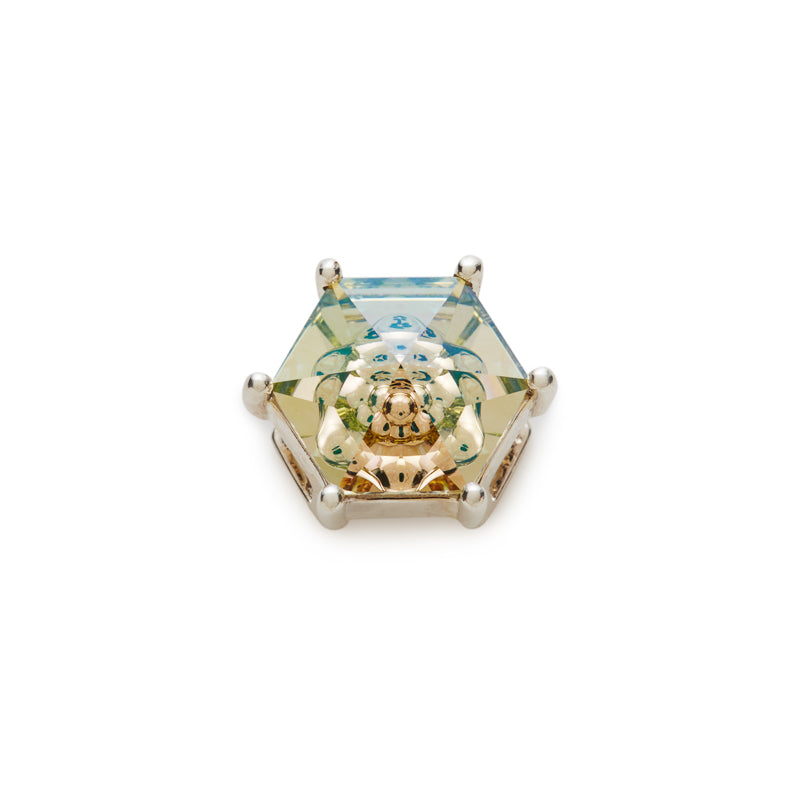 A hexagonal faceted crystal gemstone displaying a blue to yellow color gradient, set in silver metal, with a golden internal kaleidoscope reflection