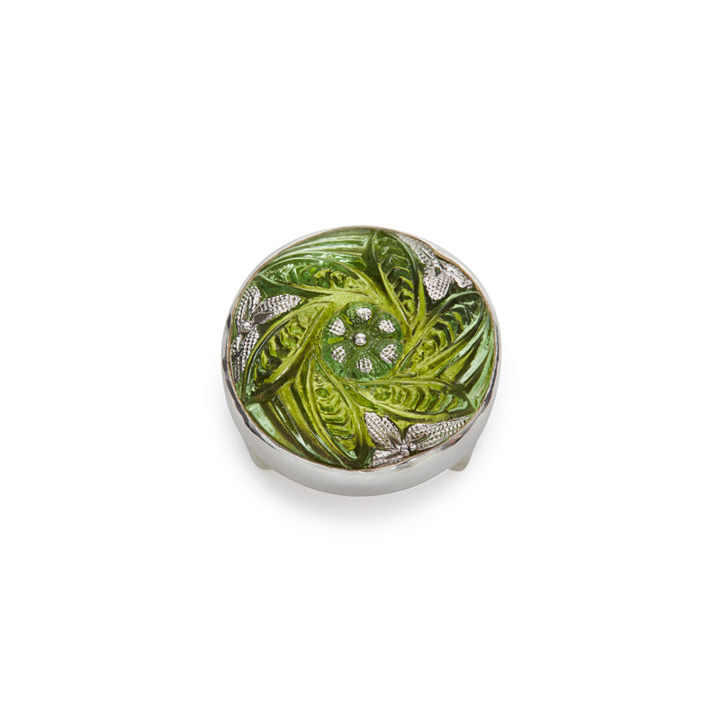 Enamel and metal decorative button with vibrant lime green swirling leaves radiating from a central floral design on a textured gold field and a polished silver rim